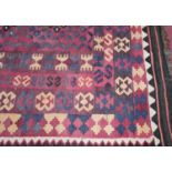 A Turkish woollen kilim rug, the repeating central design within further tramline borders, 290 x