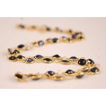A contemporary yellow metal sapphire set necklace, arranged as 42 oval cut sapphires, each