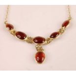 A contemporary 9ct gold cabochon garnet set necklace, arranged as five graduated cabochons with