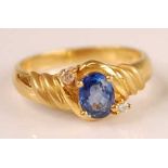 An 18ct gold Ceylon sapphire and diamond set ring, the four claw set oval cut sapphire weighing