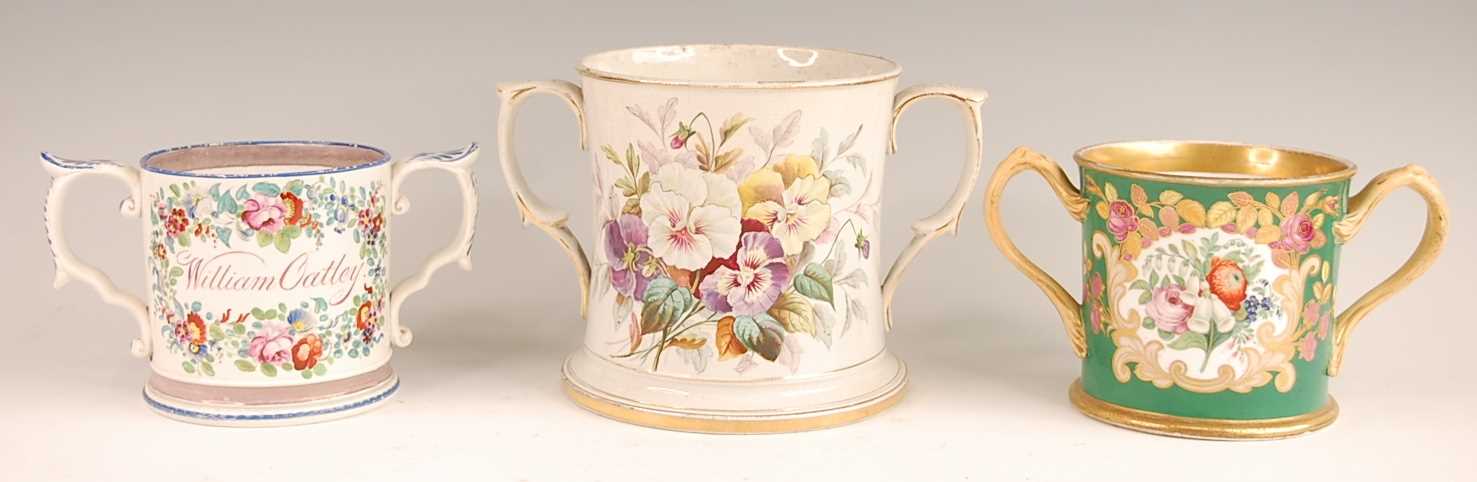 A Victorian soft-paste porcelain loving cup, enamel decorated with a floral reserve within gilt