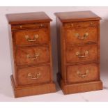 A pair of walnut and figured walnut three drawer bedside chests, each having crossbanded tops and