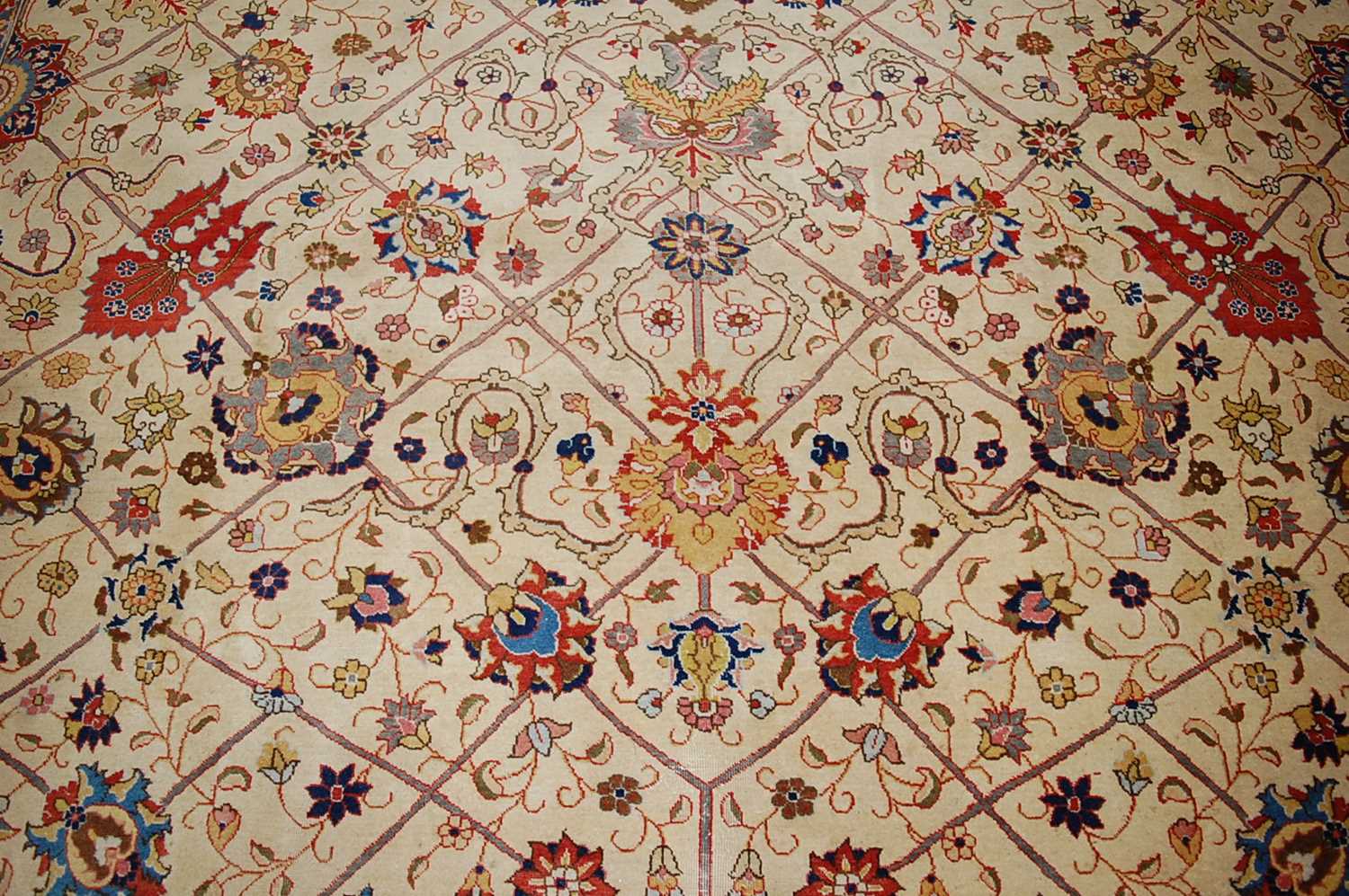 A Persian woollen cream ground carpet, decorated with scroll flowers and foliage within trailing - Image 8 of 24