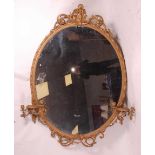 A Victorian giltwood and gesso wall mirror, of good size, the oval plate within a leaf moulded