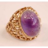 A 9ct yellow gold amethyst dress ring, featuring an oval cabochon cut amethyst in a bezel setting,