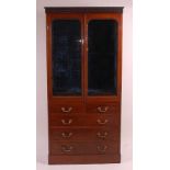 A Victorian mahogany wall cabinet, having a blind carved frieze over twin glazed doors, enclosing
