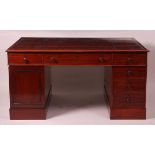 An early 19th century mahogany twin pedestal partner's desk, having a tooled leather writing