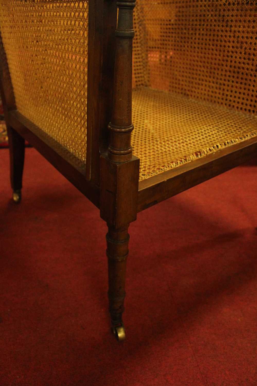 A 19th century mahogany Bergere library chair, having split cane back, side and seat, raised on ring - Image 7 of 10