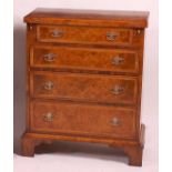 A walnut and figured walnut bachelor's chest, in the early 18th century style, having a fold-over