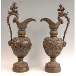A pair of late 19th century Renaissance Revival bronze Cellini ewers, each cast with a bas relief