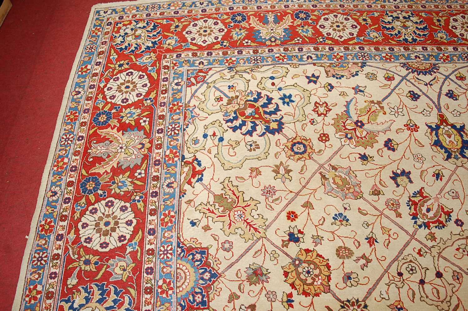 A Persian woollen cream ground carpet, decorated with scroll flowers and foliage within trailing - Image 10 of 24