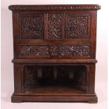 An antique joined and heavily floral relief carved oak cupboard on stand, the twin doors with