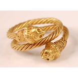 A yellow metal Etruscan style twisted three-strand crossover style ring, having granulated lion head