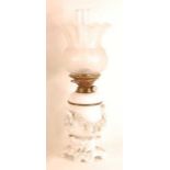 An early 20th century continental porcelain blanc-de-chine oil lamp, having clear acid etched shade,