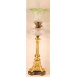 A gilt bronze pedestal oil lamp, having a green tinted acid etched shade, hobnail and diamond cut