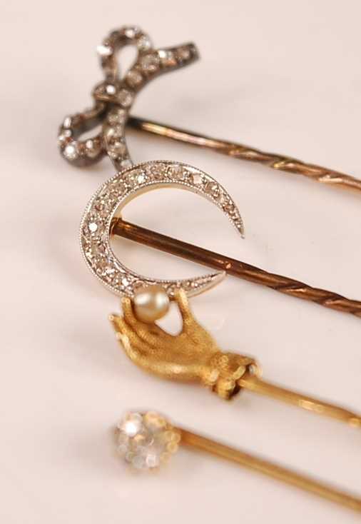 A yellow metal and diamond set stick pin, the old cut claw set diamond weighing approx 0.25