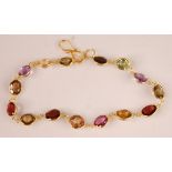A contemporary yellow metal multi-stone bracelet, featuring 15 round and oval cut amethyst, citrine,