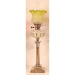 A silver plated pedestal oil lamp, having a green tinted and acid etched shade, over a cut glass