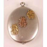 A heavy white metal oval locket, having three pairs of monogrammed initials embossed diagonally