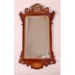 A Victorian walnut fret carved wall mirror, in the Chippendale style, having parcel-gilt carved ho-