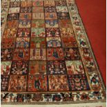 A Turkish woollen rug, the ground decorated with five rows of boxed medallions, each with