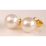 A pair of yellow metal and Japanese pearl ear studs, pearl dia. approx 9.5mm, stem unmarked but