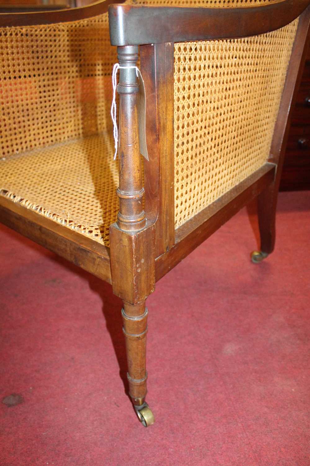 A 19th century mahogany Bergere library chair, having split cane back, side and seat, raised on ring - Image 8 of 10