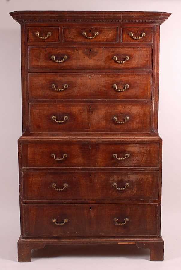 An early George III walnut chest-on-chest, the upper section having a dentil moulded cornice above