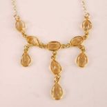 A contemporary 9ct gold citrine set necklet, arranged as nine oval cut citrine, each weighing approx