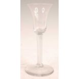A mid-18th century wine glass, the waisted bell bowl over clear glass spiral twist column to a