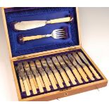 A late Victorian walnut cased canteen of twelve silver plated fish knives and forks, together with