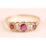 A yellow metal, ruby and diamond half hoop eternity ring, featuring three graduated oval rubies