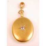 A yellow metal oval diamond set locket, comprising an oval diamond in a star setting, with a