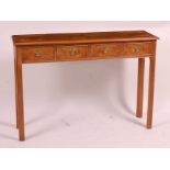 A walnut and burr walnut four drawer hall table, having a cross and feather banded top, raised on