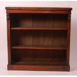 A Victorian walnut freestanding open bookshelf, having moulded pilasters and raised upon a plinth,