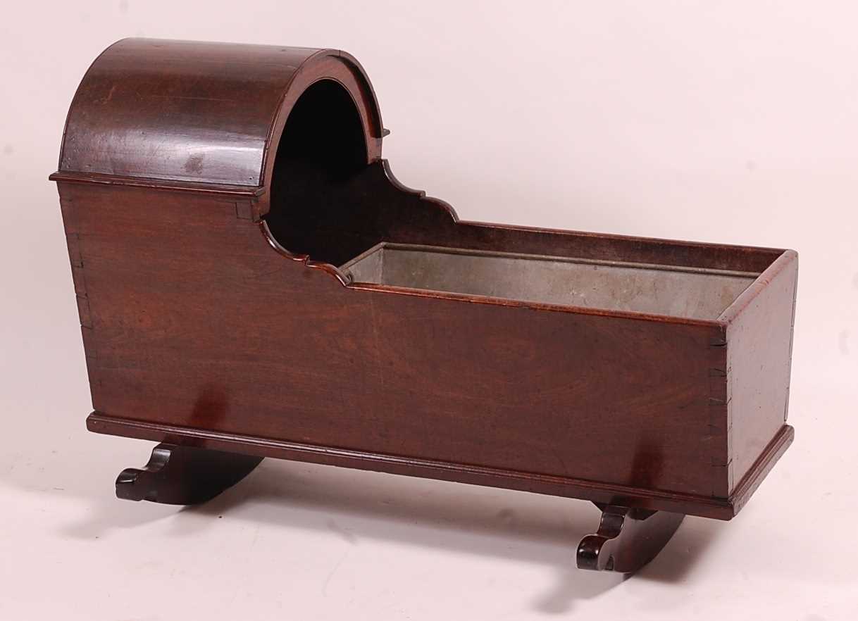 An 18th century mahogany child's crib, having a domed hood and on twin rockers, w.97cm, h.68cm, with