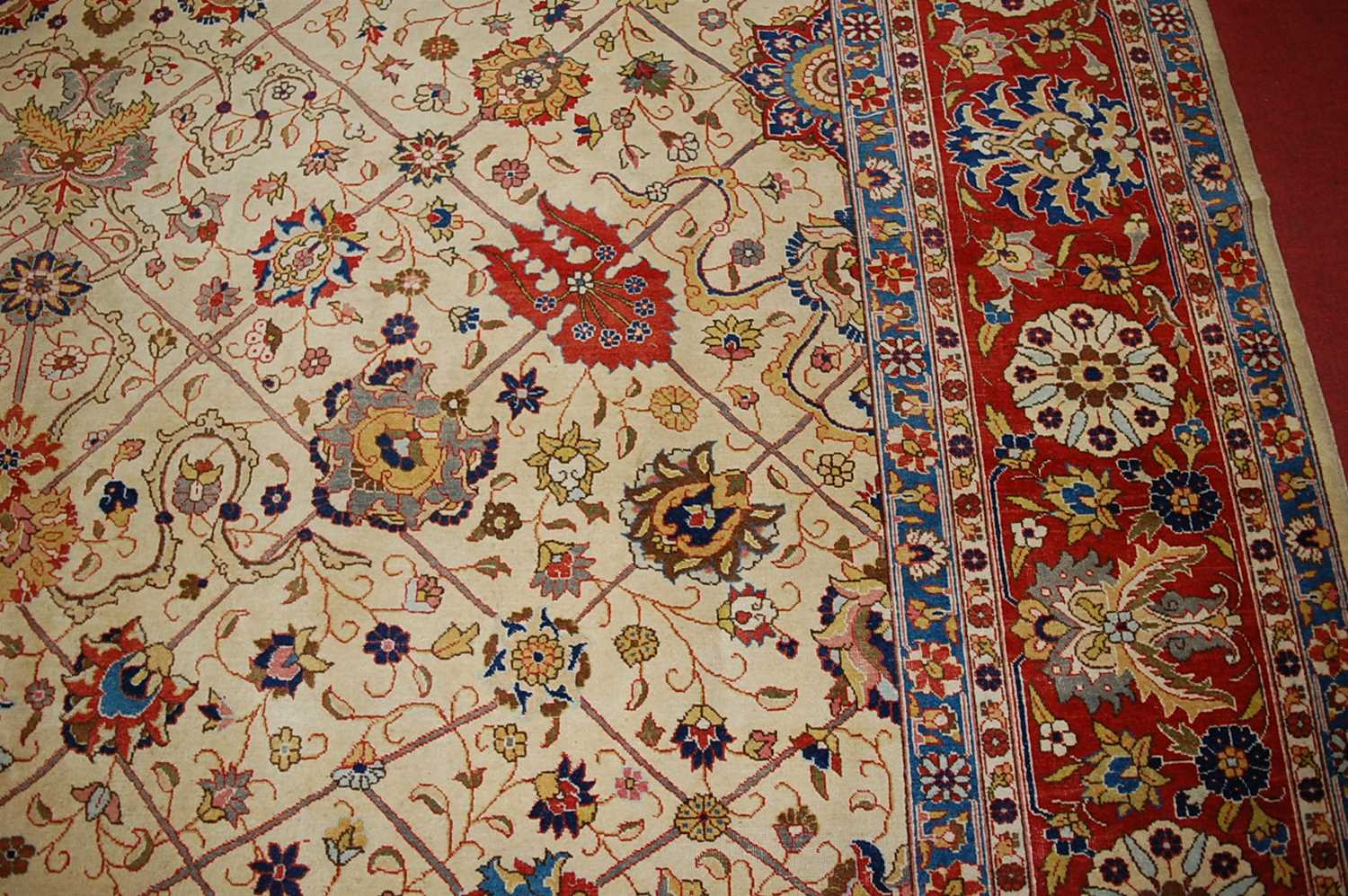 A Persian woollen cream ground carpet, decorated with scroll flowers and foliage within trailing - Image 7 of 24