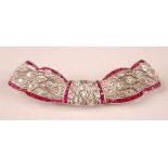 An Art Deco style white metal, ruby and diamond swag shaped bar brooch, comprising 81 Old European