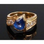 An 18ct yellow gold, tanzanite and diamond crossover style ring, featuring a pear cut tanzanite in a
