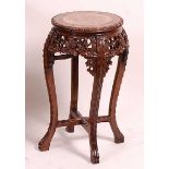 A circa 1900 Chinese 'rosewood' and variegated marble inset low jardiniere stand, of circular