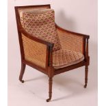 A 19th century mahogany Bergere library chair, having split cane back, side and seat, raised on ring