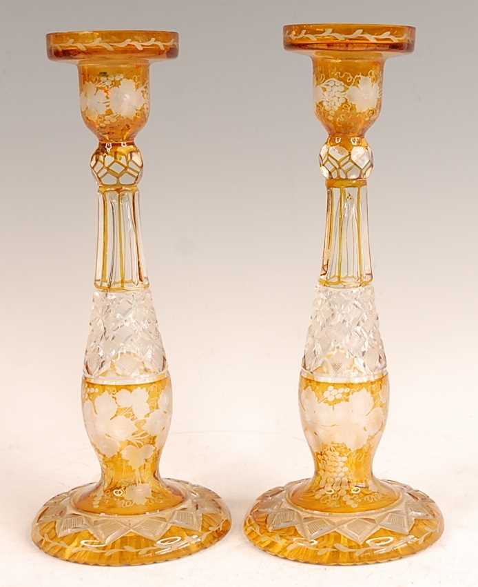 A pair of Bohemian cut and amber flash glass candle-holders, each further acid etched with