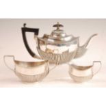 A George V bachelors three-piece silver tea set, comprising teapot, twin handled sugar and cream,