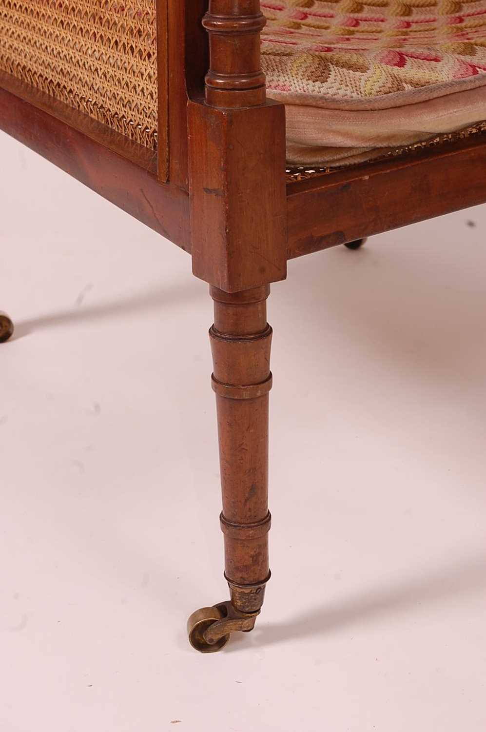 A 19th century mahogany Bergere library chair, having split cane back, side and seat, raised on ring - Image 2 of 10