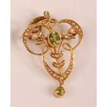 A yellow metal Edwardian peridot and seed pearl openwork pendant featuring a centre oval faceted