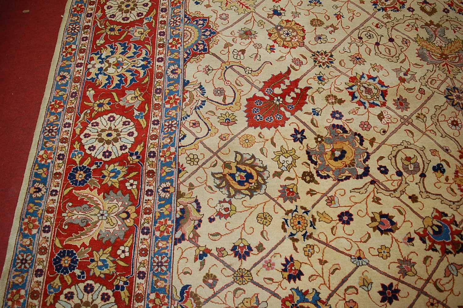 A Persian woollen cream ground carpet, decorated with scroll flowers and foliage within trailing - Image 9 of 24