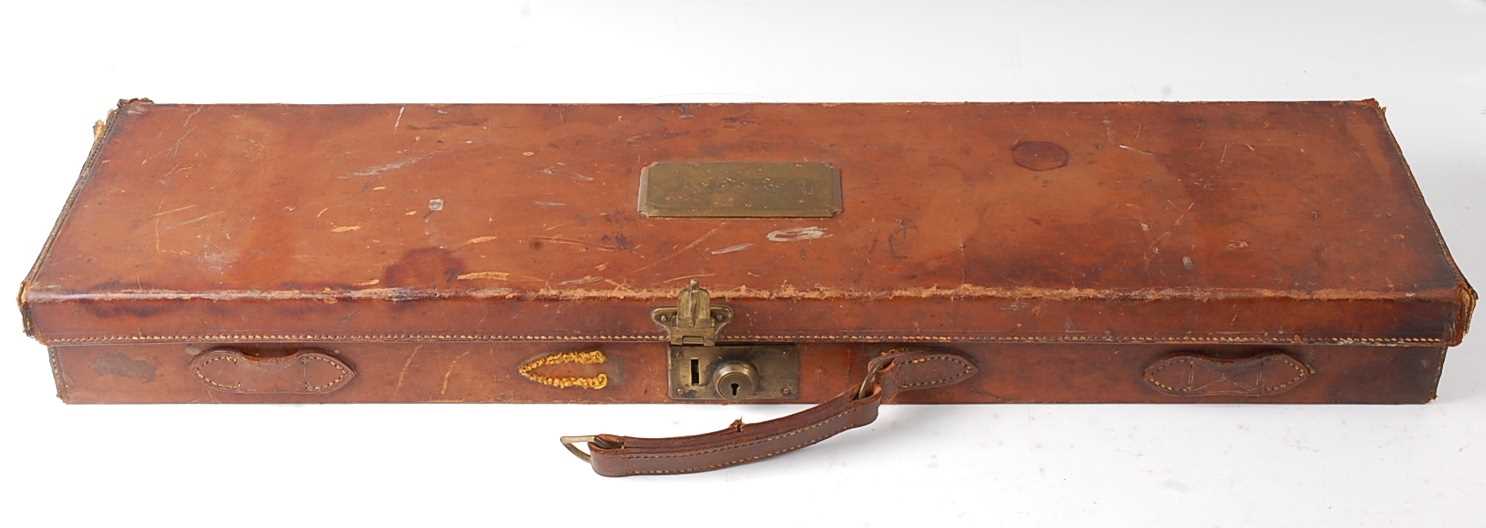 An early 20th century brown leather shotgun case, the lid with a brass plaque initialled A.D.B.H.,