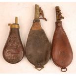 An early 20th century copper powder flask, of pear shaped each side embossed with birds and a dog,