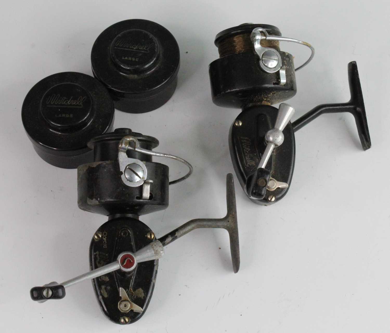 A Mitchell 300 left hand fixed spool reel, together with one other Mitchell left hand reel and two