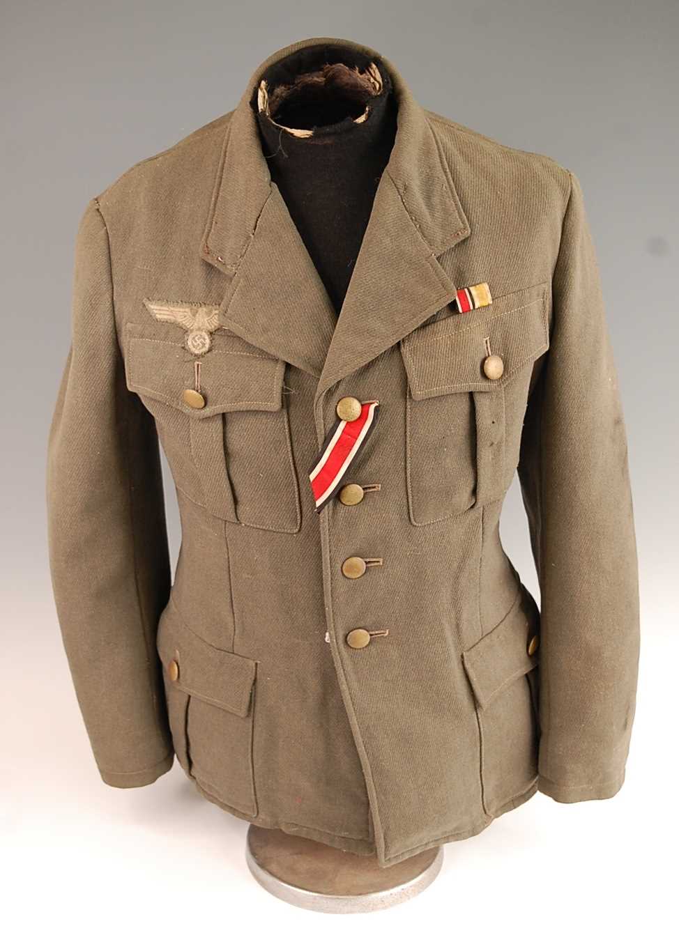 A German Army tunic, in green having four pleated pockets with pebble effect buttons and War Service